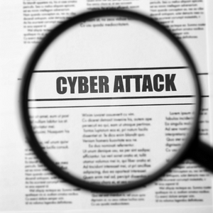 Magnifying glass over news headline reading "cyber attack"