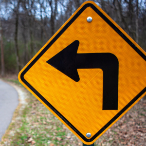 Yellow traffic sign depicting an arrow pointing left